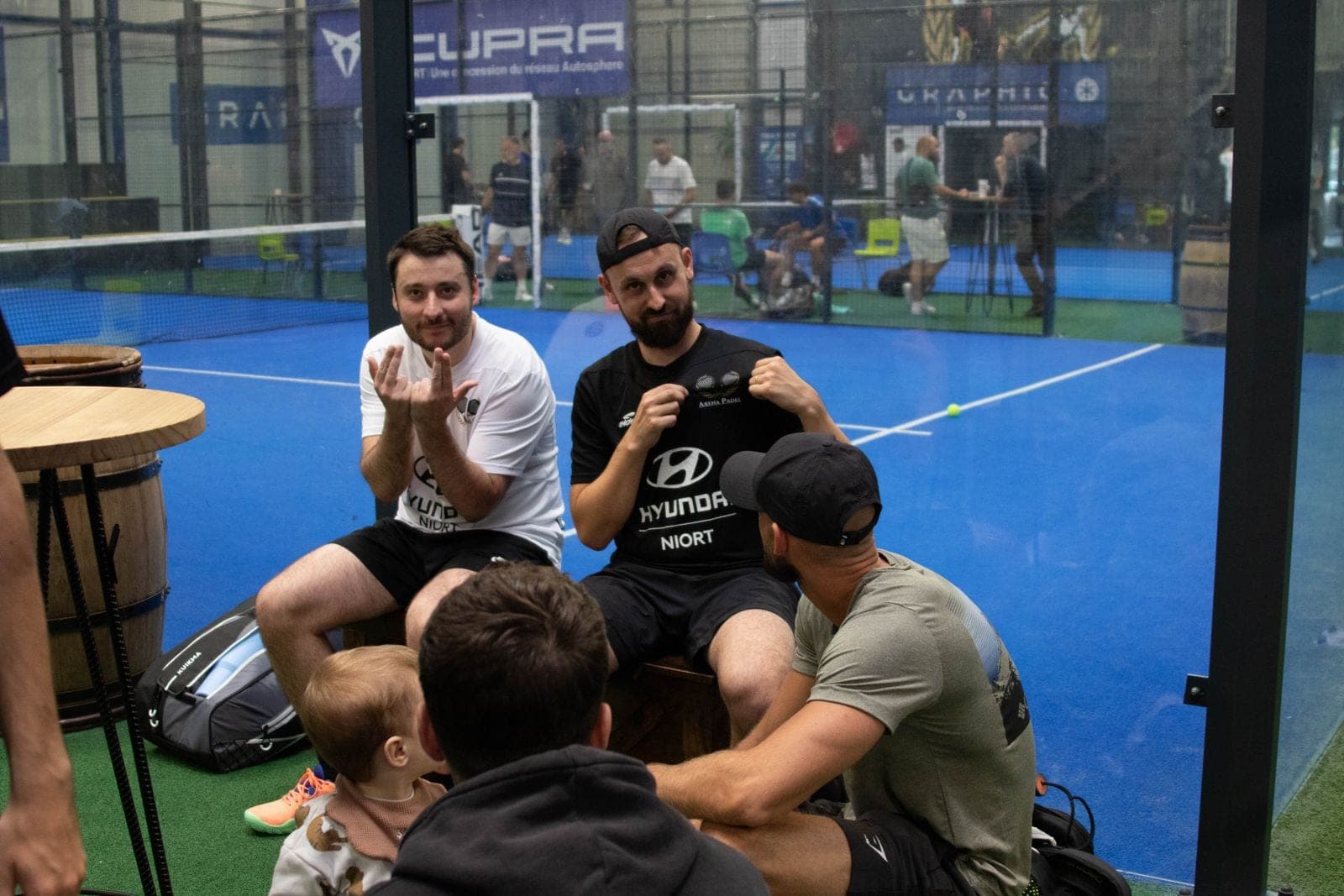 Joueurs hilares au bord d’un terrain bleu pendant le tournoi interne 2026