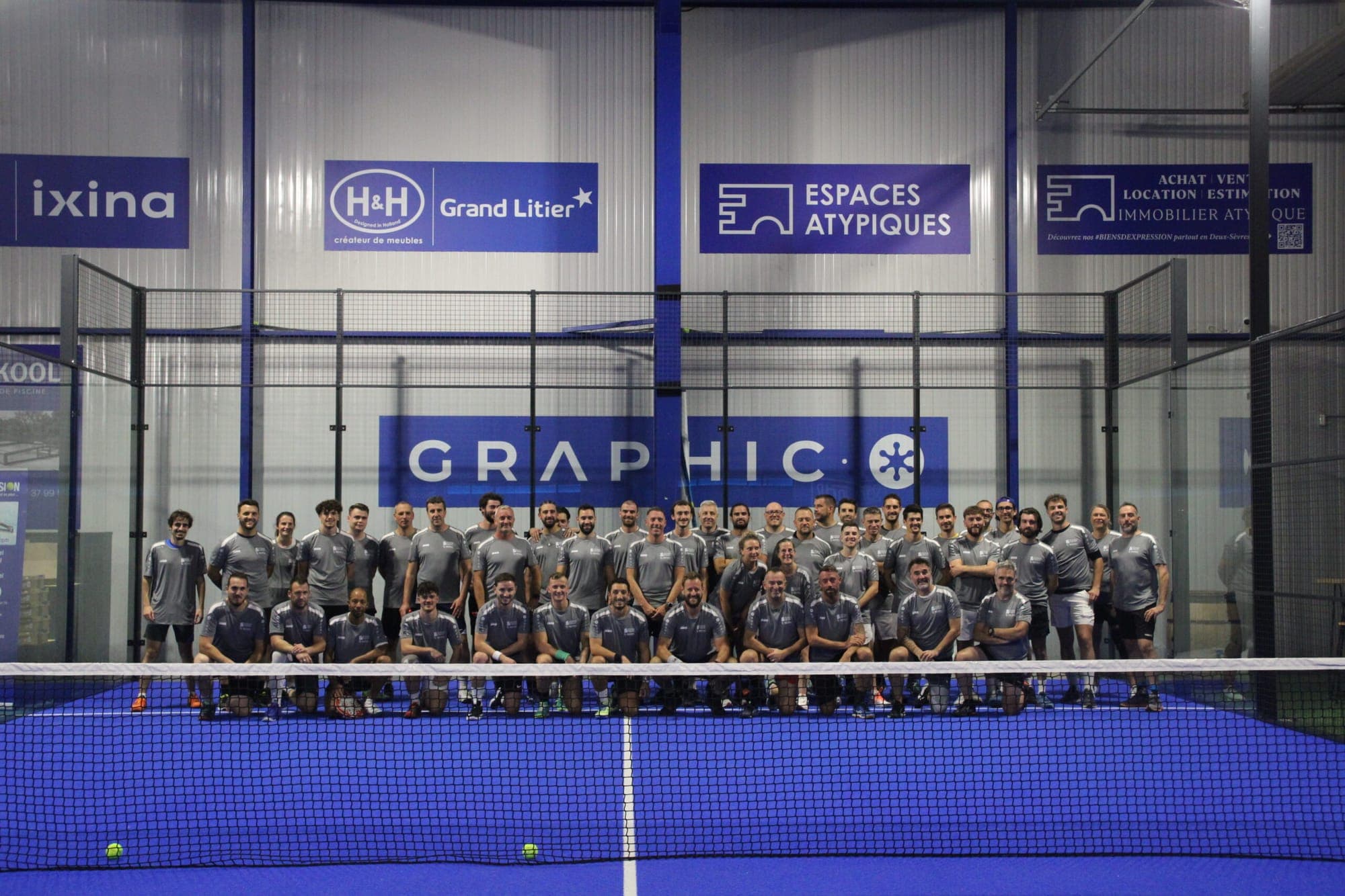 Grande photo de groupe de joueurs réunis sur un terrain bleu de l’Arena